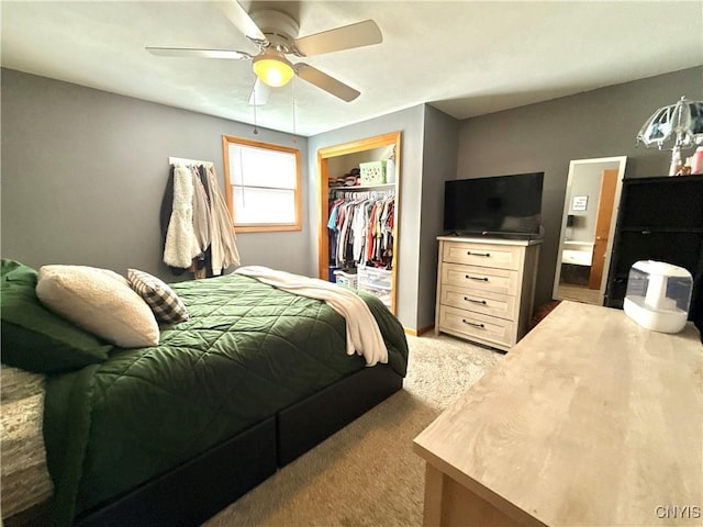 bedroom featuring ceiling fan, a closet, a walk in closet, and light colored carpet