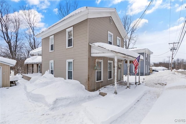 view of snowy exterior featuring a garage