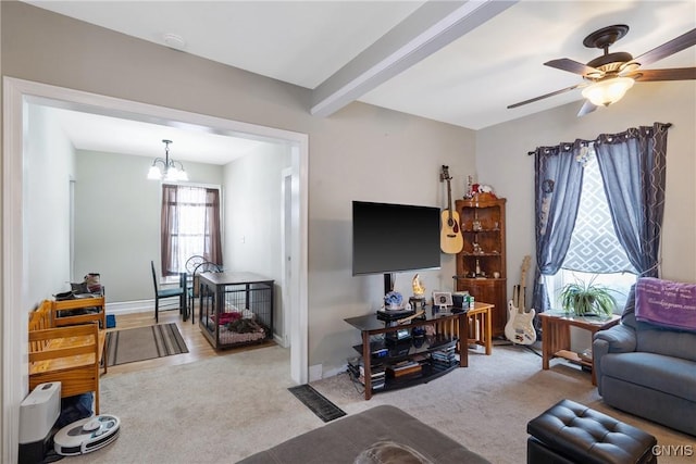 living area featuring beam ceiling, light carpet, baseboards, and ceiling fan with notable chandelier