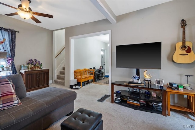 living area with carpet floors, beamed ceiling, stairway, and a ceiling fan