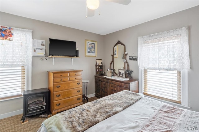 213 Salisbury St, Sandy Creek, NY 13145 - bedroom featuring baseboards, a wood stove, and a ceiling fan