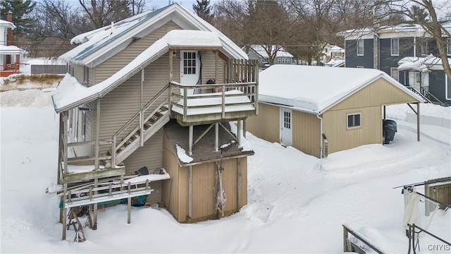 snow covered property with stairs