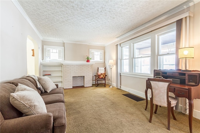 carpeted living area featuring a fireplace, crown molding, visible vents, a textured ceiling, and baseboards