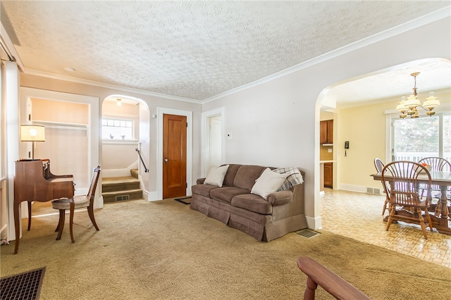 living area featuring visible vents, arched walkways, stairs, a textured ceiling, and crown molding