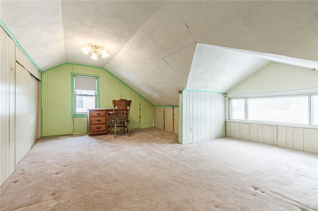 additional living space with a healthy amount of sunlight, carpet, and vaulted ceiling