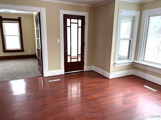 entryway featuring dark wood-style flooring, a wealth of natural light, and crown molding