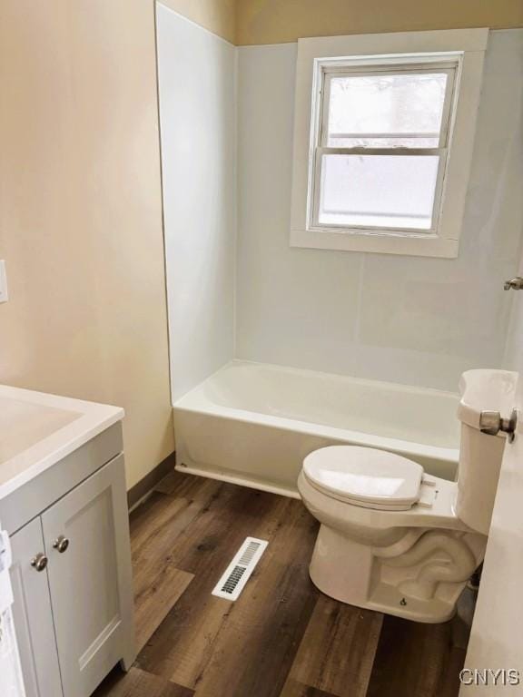 bathroom with shower / bathtub combination, visible vents, toilet, vanity, and wood finished floors