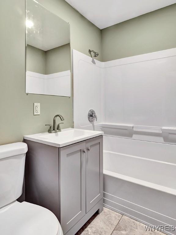 full bath with toilet, tile patterned flooring, vanity, and bathing tub / shower combination