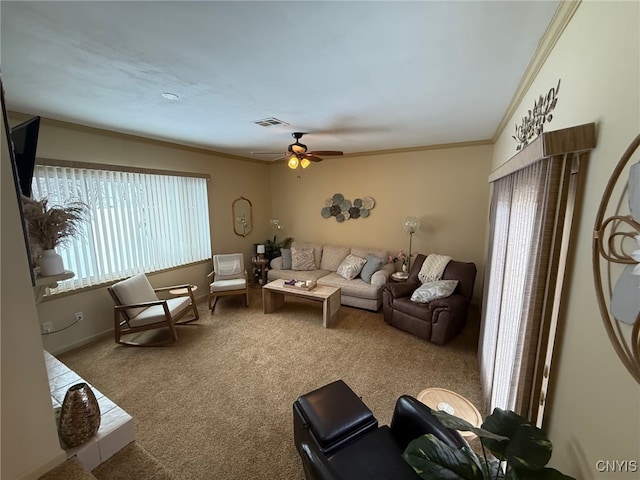 carpeted living room with visible vents, ornamental molding, ceiling fan, and baseboards