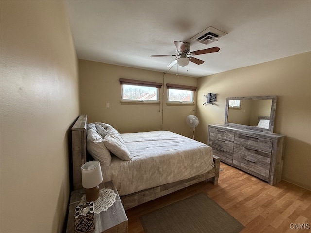 bedroom featuring ceiling fan, light wood finished floors, and visible vents