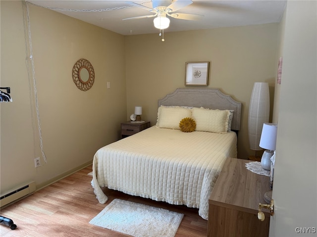 bedroom with ceiling fan, a baseboard radiator, and light wood-style flooring