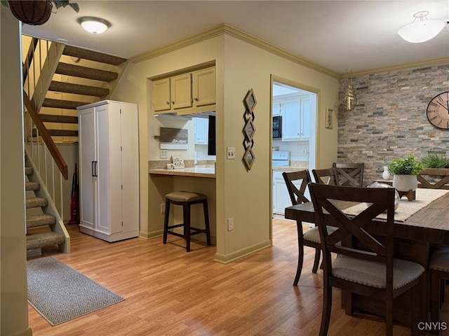 dining room featuring baseboards, stairway, light wood-style flooring, and crown molding