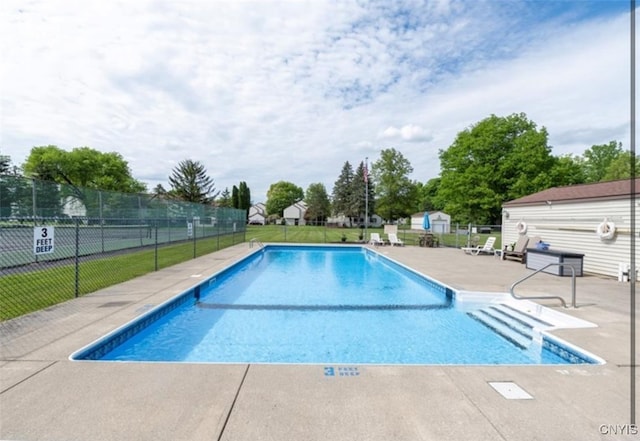 community pool with fence and a patio