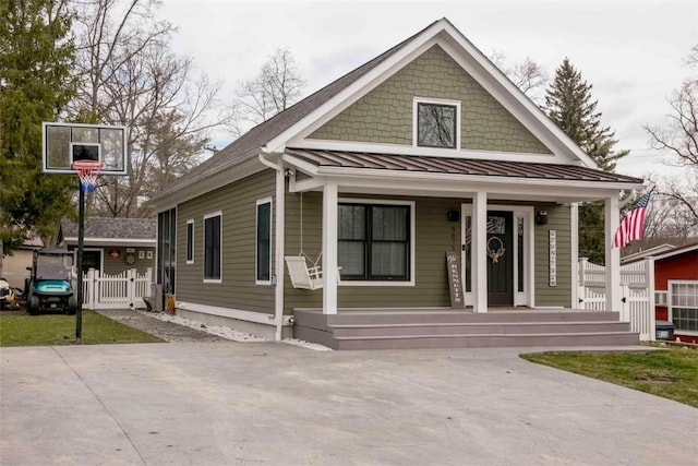 bungalow-style home featuring covered porch and a standing seam roof