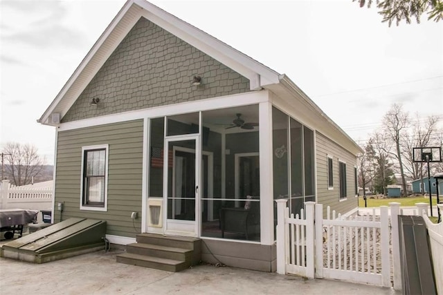 view of side of property with entry steps, a patio, fence, and a sunroom