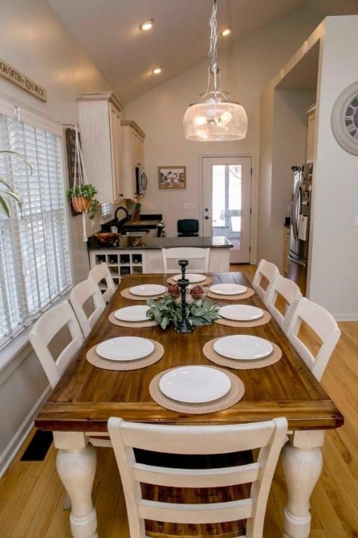 dining area with light wood-style floors, recessed lighting, vaulted ceiling, and baseboards