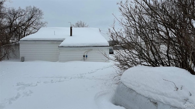 snow covered property featuring a detached garage