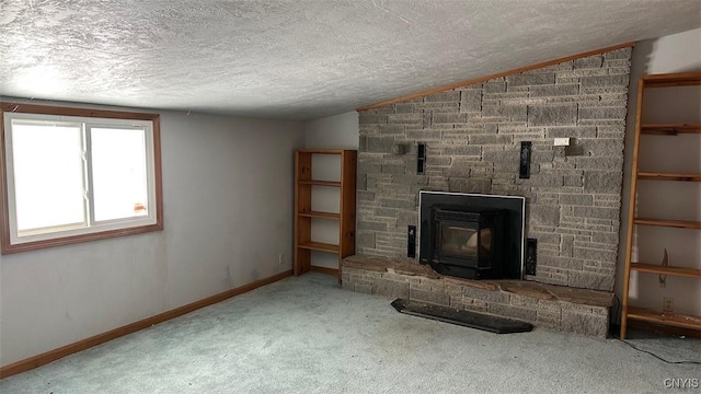 unfurnished living room with baseboards, lofted ceiling, carpet, a textured ceiling, and a stone fireplace