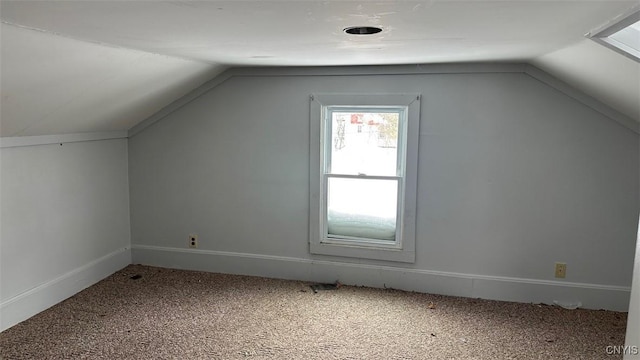 additional living space with baseboards, vaulted ceiling, and carpet flooring