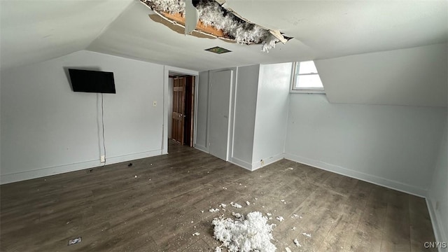 bonus room with dark wood-style flooring, vaulted ceiling, and baseboards