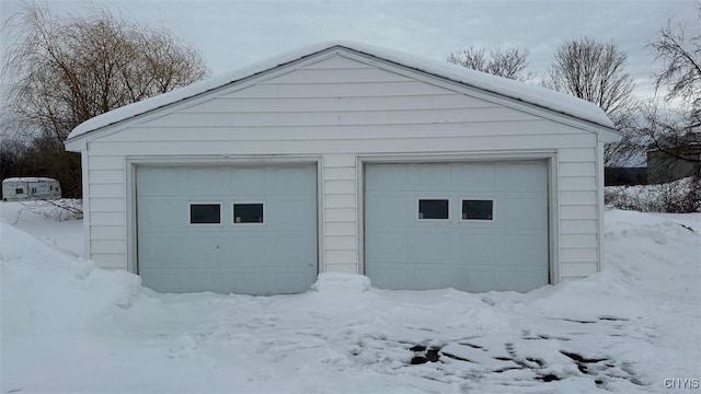 snow covered garage featuring a garage