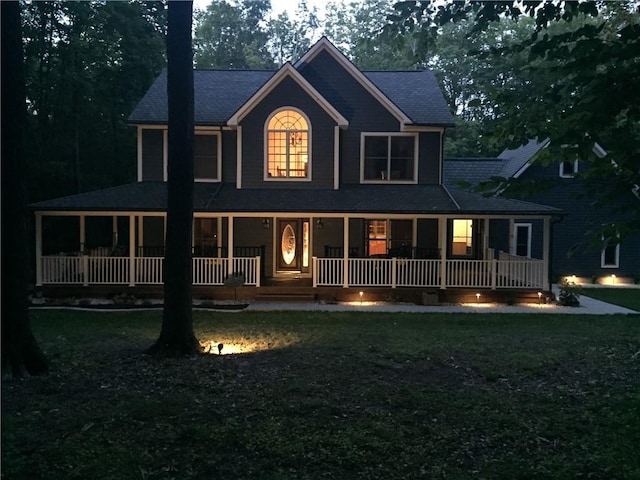 rear view of house featuring a porch and a lawn