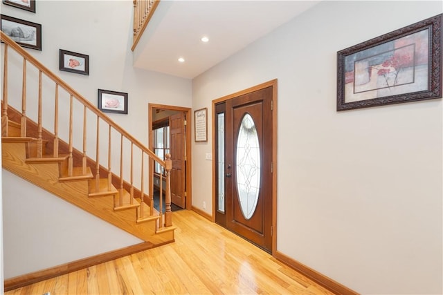 foyer entrance featuring recessed lighting, light wood-style flooring, baseboards, and stairs