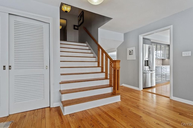 staircase with hardwood / wood-style floors and baseboards