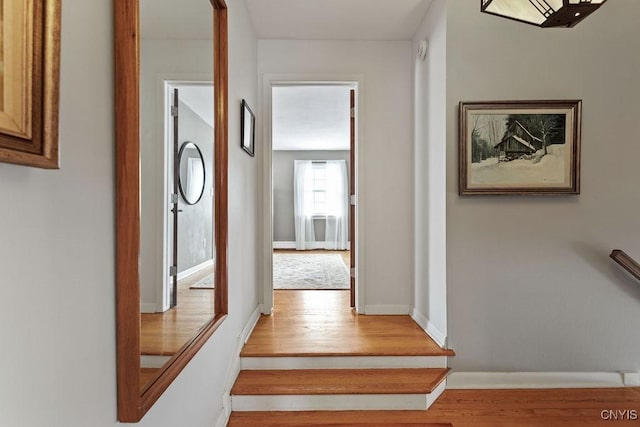 hallway featuring light wood-style flooring and baseboards