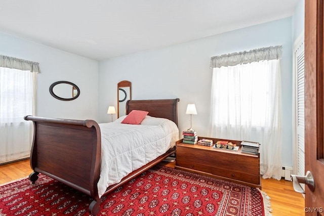 bedroom featuring a baseboard radiator and wood finished floors