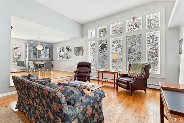 living room featuring light wood-style floors, a baseboard radiator, a baseboard heating unit, and baseboards