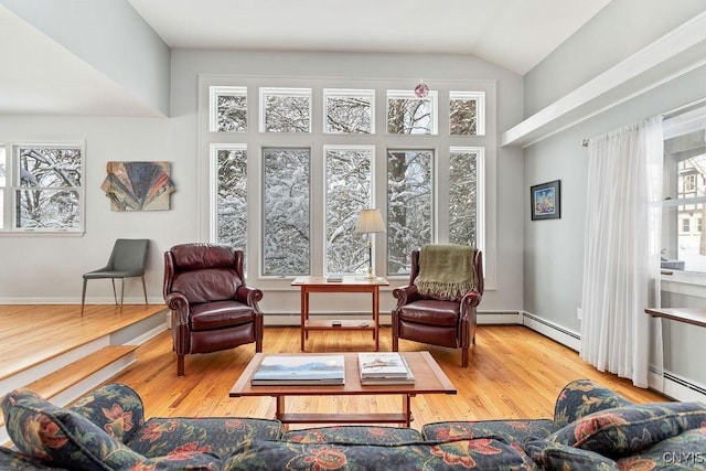 sitting room featuring plenty of natural light, vaulted ceiling, and wood finished floors