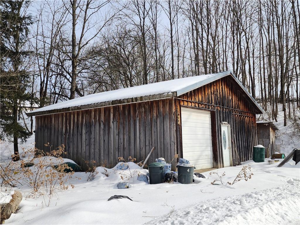 snow covered garage featuring a garage and cooling unit