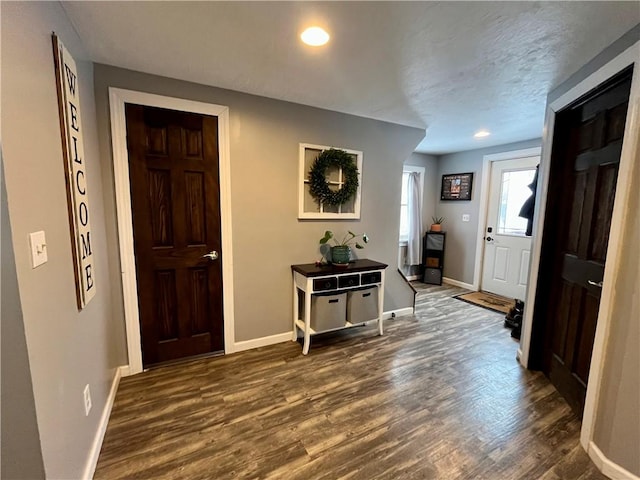 entrance foyer featuring dark wood-style floors, a textured ceiling, and baseboards