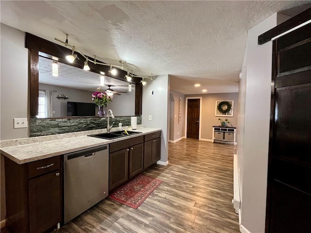 kitchen with dishwasher, wood finished floors, light countertops, dark brown cabinets, and a sink