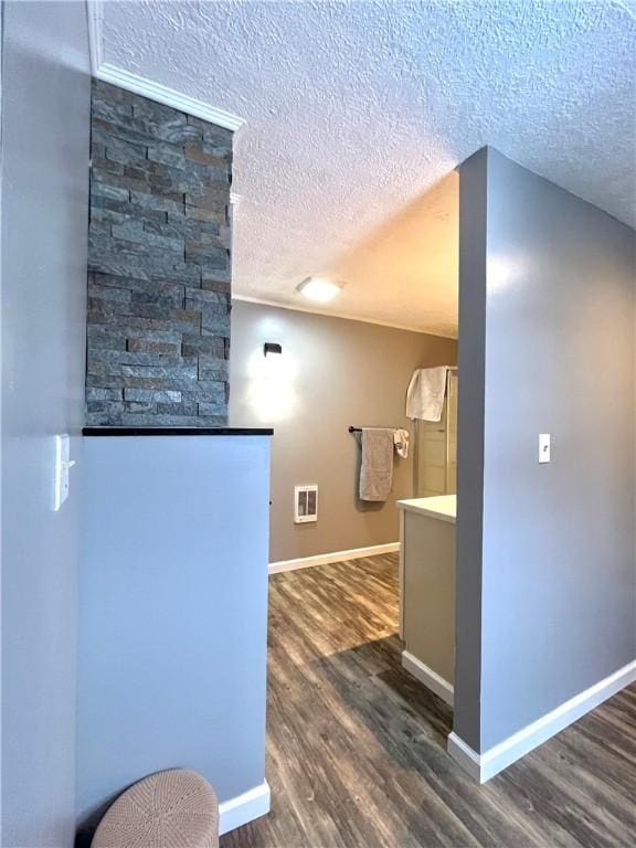 kitchen featuring a textured ceiling, dark wood finished floors, and baseboards