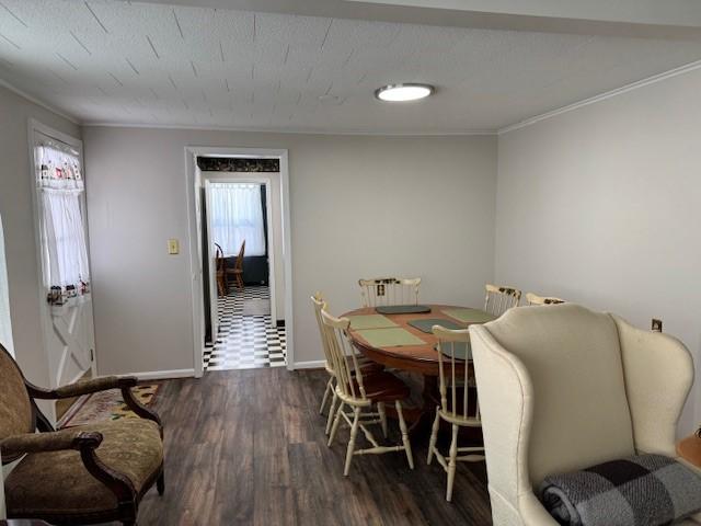 dining area with baseboards, dark wood finished floors, and ornamental molding