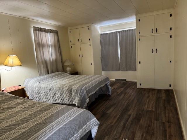 bedroom with visible vents, baseboards, and wood finished floors