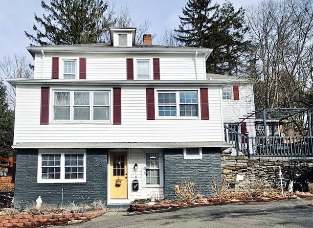 american foursquare style home with a chimney