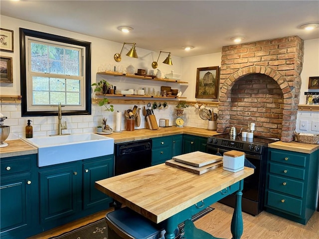 kitchen with butcher block counters, a sink, black appliances, and open shelves