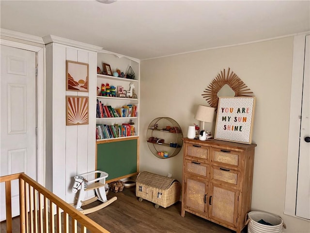 bedroom with a crib and dark wood-style flooring