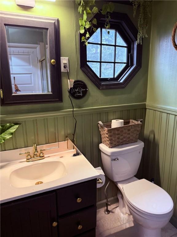 bathroom featuring wainscoting, vanity, and toilet