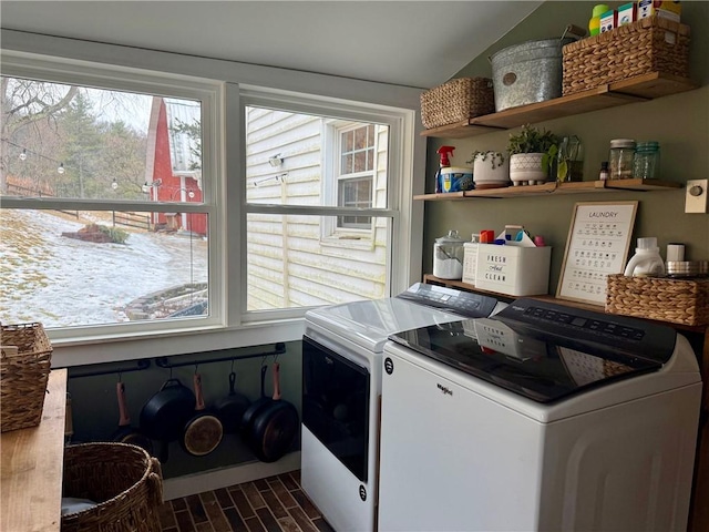 clothes washing area featuring wood tiled floor, laundry area, plenty of natural light, and washing machine and clothes dryer