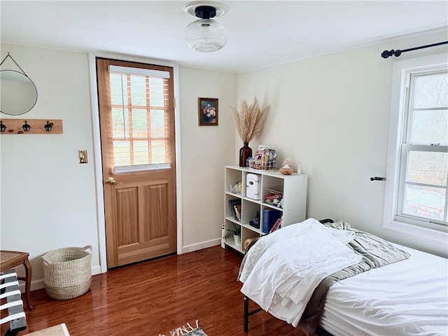 bedroom with dark wood-style floors and baseboards