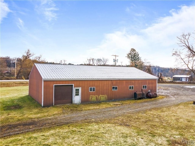 3391 State Route 28, Herkimer, NY 13350 - view of side of home with an outbuilding, metal roof, a garage, dirt driveway, and a yard