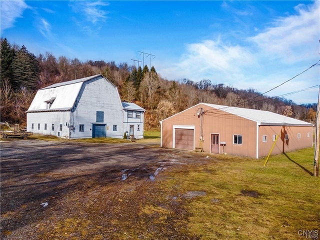 3391 State Route 28, Herkimer, NY 13350 - view of home's exterior with an outbuilding, a detached garage, a gambrel roof, driveway, and a yard