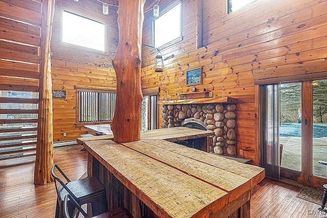 3391 State Route 28, Herkimer, NY 13350 - dining area featuring wood walls, wood-type flooring, a high ceiling, and a fireplace