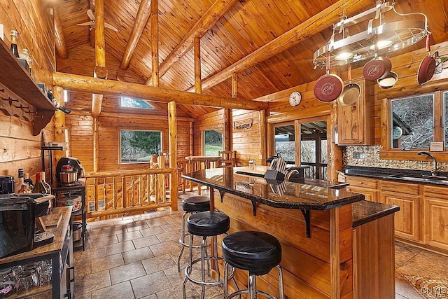 3391 State Route 28, Herkimer, NY 13350 - kitchen with wooden walls, a breakfast bar, a sink, brown cabinets, and dark countertops
