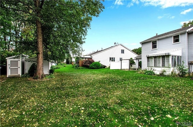 view of yard with an outbuilding, a storage unit, and fence