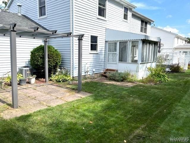 back of house featuring a sunroom, central AC unit, a pergola, and a yard